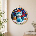 Blue christmas cat with houses needle felt wall art displayed in a bright home interior