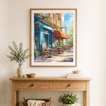 Finished blue corner cafe with red awning cross stitch artwork displayed as home decor