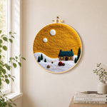Blue-roof cottage under the yellow sky needle felt wall art displayed in a bright home interior