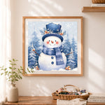Finished blue top hat snowman and forest cross stitch artwork displayed as home decor