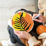 Creating handmade bold black and yellow leaf punch needle artwork