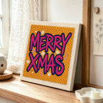 Bold merry xmas lettering punch needle artwork displayed on a table