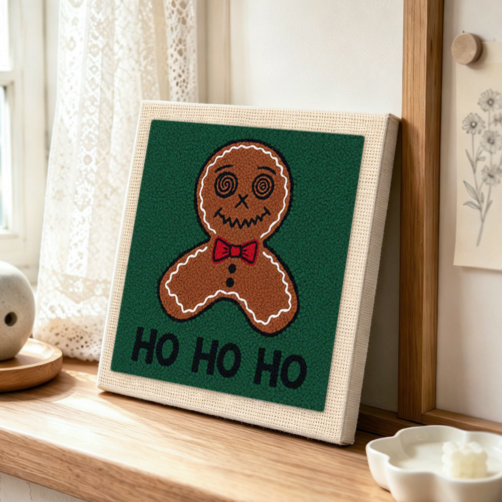 Bow tie gingerbread man art punch needle artwork displayed on a table