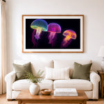Finished bright bioluminescent jellyfish cross stitch artwork displayed as home decor