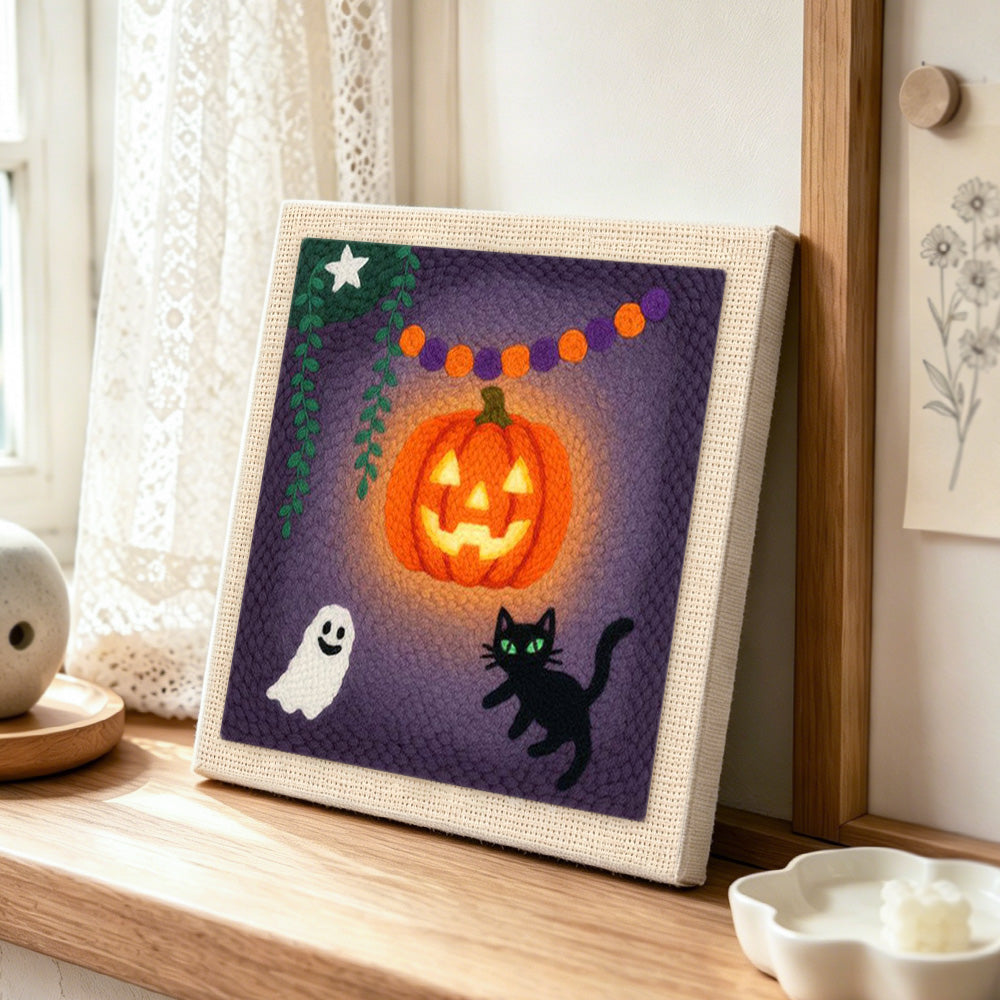 Bright glowing pumpkin punch needle artwork displayed on a table
