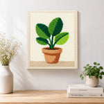 Finished broad leaf potted plant artwork displayed on a wall