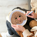 Creating handmade brown puppy punch needle artwork