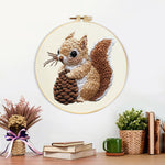 Finished brown squirrel holding pine cone artwork displayed on a wall