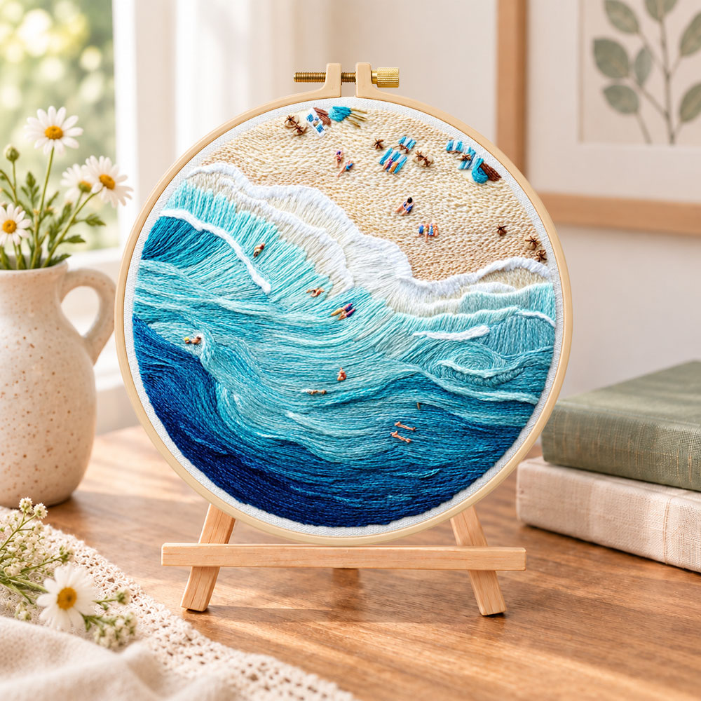 Bustling ocean surf embroidery kit finished hoop displayed on a wooden stand as cozy tabletop decor