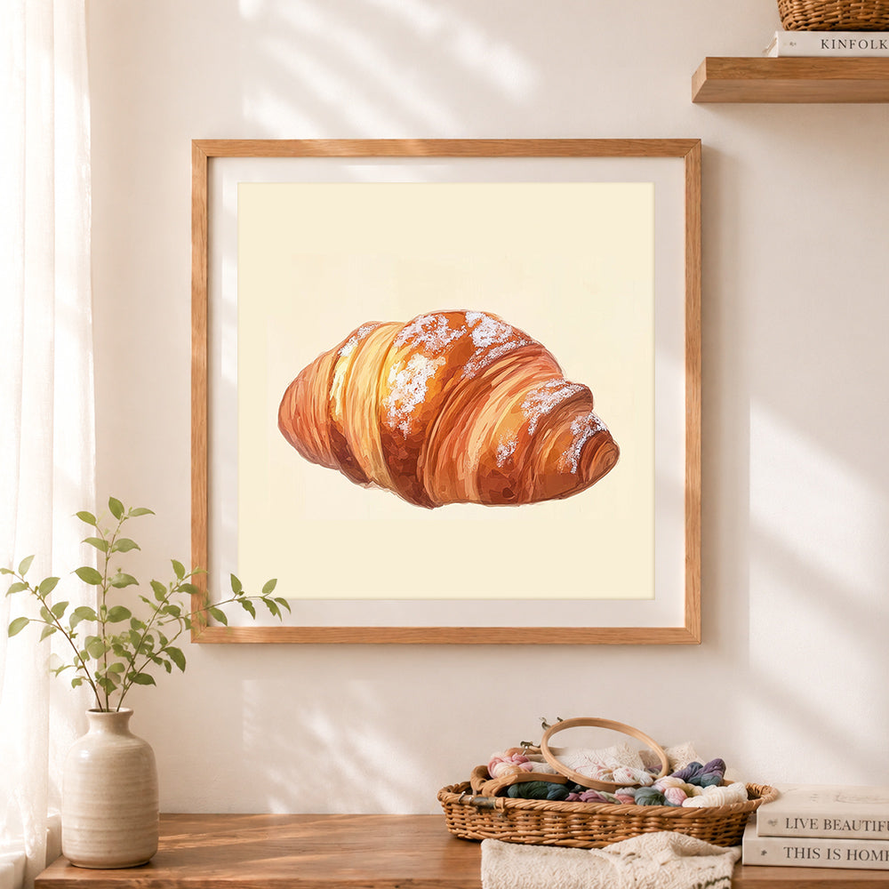 Finished buttery croissant with powdered sugar cross stitch artwork displayed as home decor