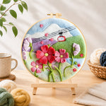 Finished cable car over mountain flowers needle felting displayed on a wooden easel