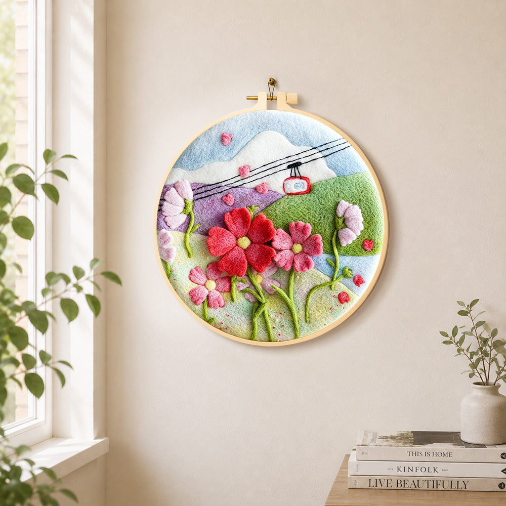 Cable car over mountain flowers needle felt wall art displayed in a bright home interior