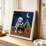 Camping skeleton punch needle artwork displayed on a table