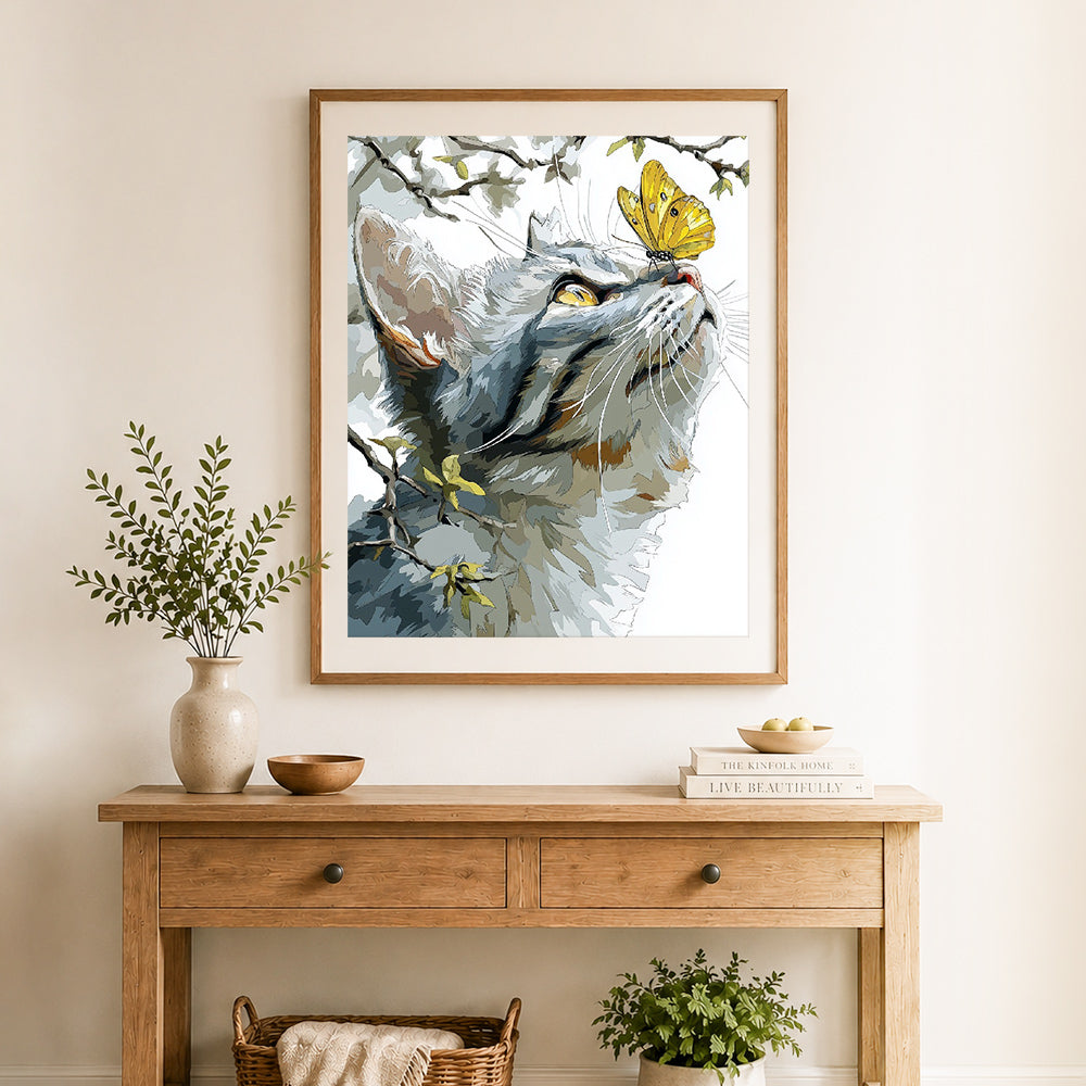 Finished cat and golden butterfly cross stitch artwork displayed as home decor