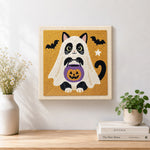 Finished cat ghost with pumpkin bucket artwork displayed on a wall