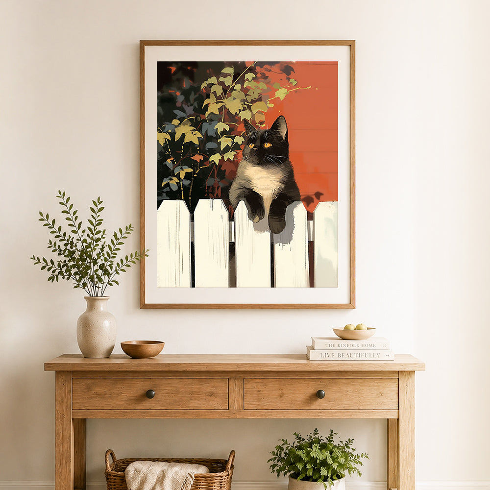 Finished cat resting on white fence cross stitch artwork displayed as home decor