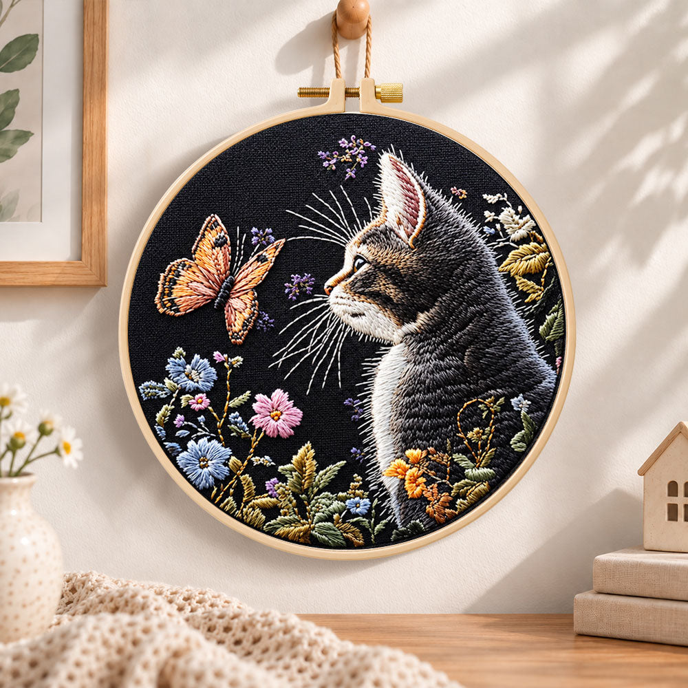 Cat watching butterfly embroidery hoop wall art displayed as warm and cozy handmade home decor