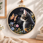 Cat watching butterfly embroidery hoop wall art displayed as warm and cozy handmade home decor