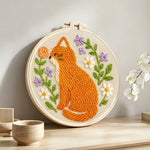 Cat with wildflowers punch needle artwork displayed on a table