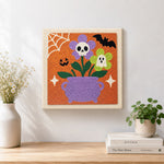 Finished cauldron spooky blooms artwork displayed on a wall