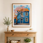 Finished cherry blossom blue house cross stitch artwork displayed as home decor