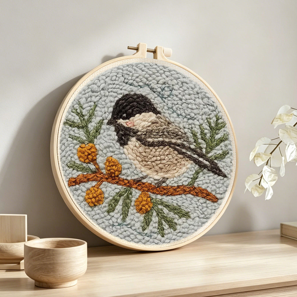 Chickadee on berry branch punch needle artwork displayed on a table