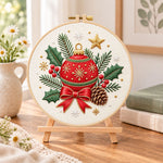 Christmas bauble ornament embroidery kit finished hoop displayed on a wooden stand as cozy tabletop decor