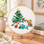Christmas bear tree embroidery kit finished hoop displayed on a wooden stand as cozy tabletop decor
