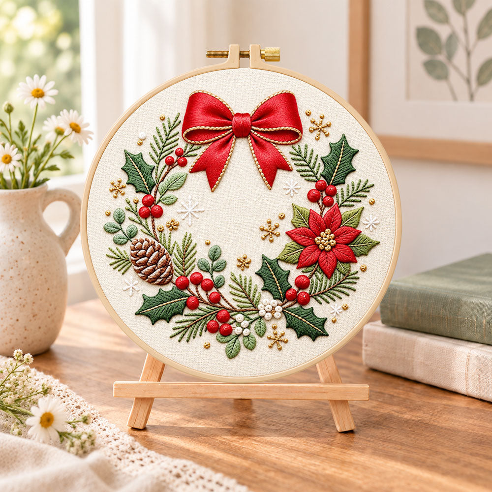 Christmas bow wreath embroidery kit finished hoop displayed on a wooden stand as cozy tabletop decor