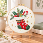 Christmas fireplace stocking embroidery kit finished hoop displayed on a wooden stand as cozy tabletop decor