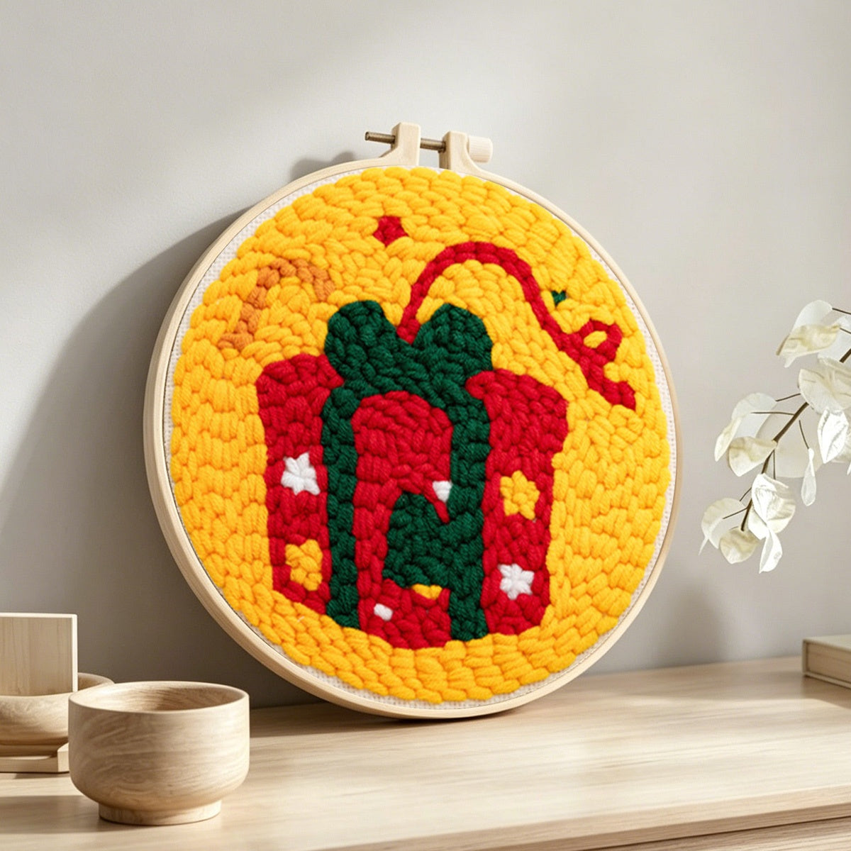 Christmas gift box punch needle artwork displayed on a table