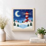 Finished christmas lighthouse scene artwork displayed on a wall