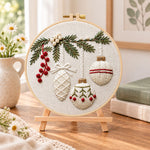Christmas ornament embroidery kit finished hoop displayed on a wooden stand as cozy tabletop decor