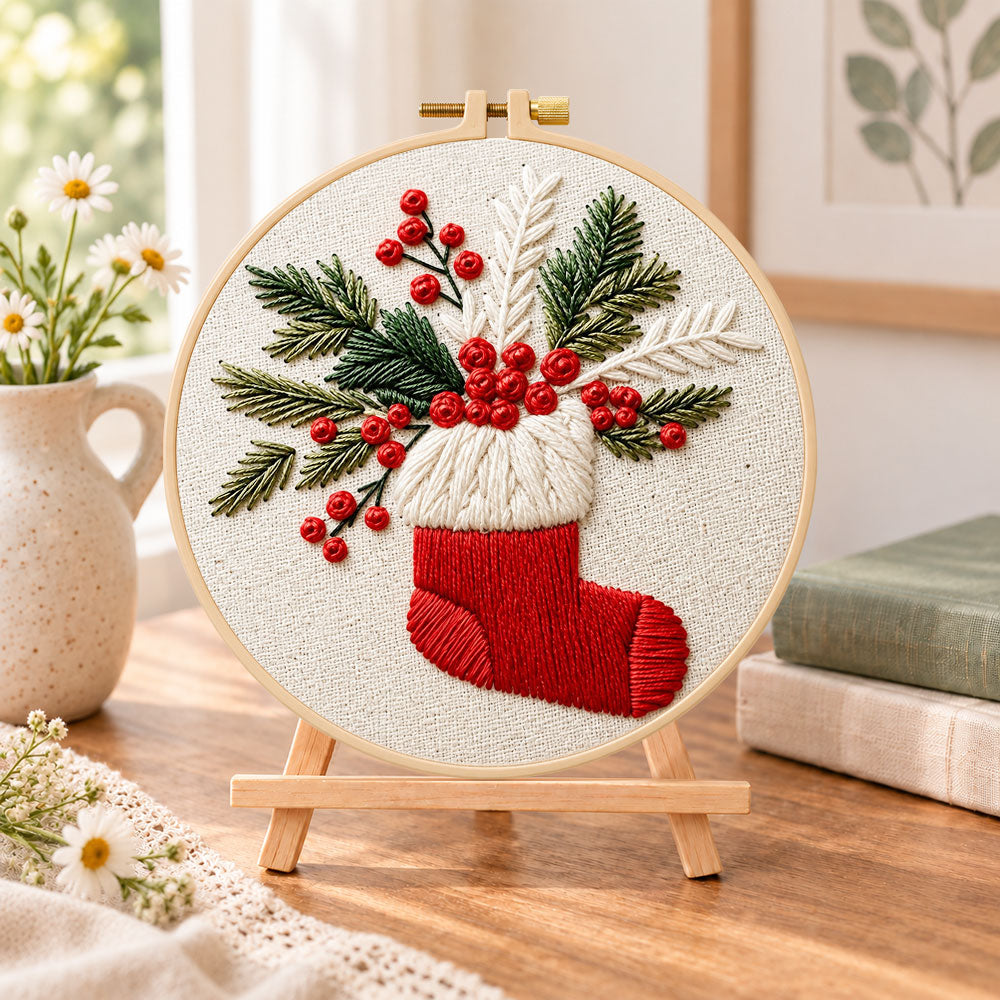 Christmas stocking embroidery kit finished hoop displayed on a wooden stand as cozy tabletop decor