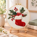 Christmas stocking embroidery kit finished hoop displayed on a wooden stand as cozy tabletop decor