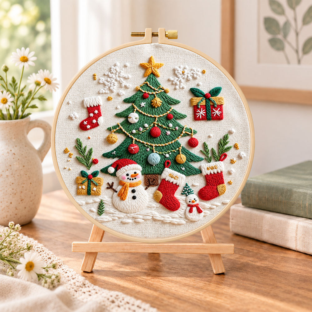 Christmas tree and snowman embroidery kit finished hoop displayed on a wooden stand as cozy tabletop decor