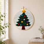 Christmas tree with colorful baubles needle felt wall art displayed in a bright home interior