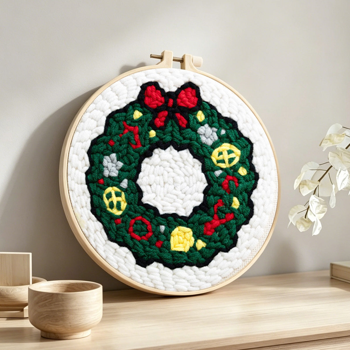 Classic green holiday wreath punch needle artwork displayed on a table