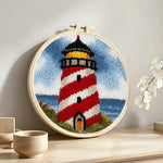 Classic red and white striped lighthouse punch needle artwork displayed on a table