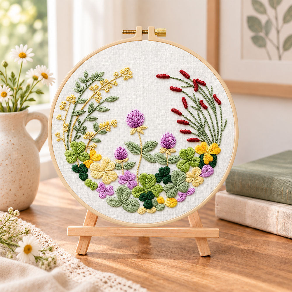Clover floral wreath embroidery kit finished hoop displayed on a wooden stand as cozy tabletop decor