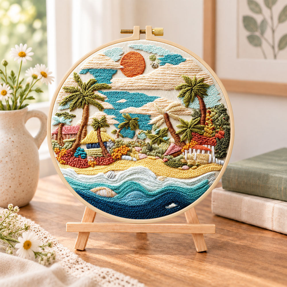 Coastal sunset cove embroidery kit finished hoop displayed on a wooden stand as cozy tabletop decor