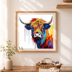 Finished color‑drip highland cow cross stitch artwork displayed as home decor