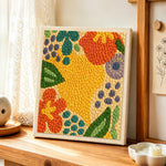 Colorful abstract botanical punch needle artwork displayed on a table