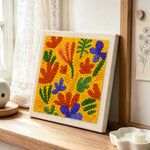 Colorful abstract petals punch needle artwork displayed on a table