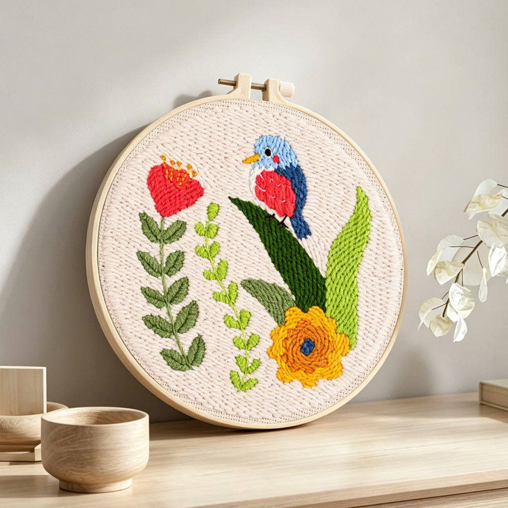 Colorful bird and flowers punch needle artwork displayed on a table
