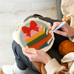 Creating handmade colorful book stack with bow punch needle artwork