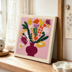 Colorful bouquet in burgundy vase punch needle artwork displayed on a table