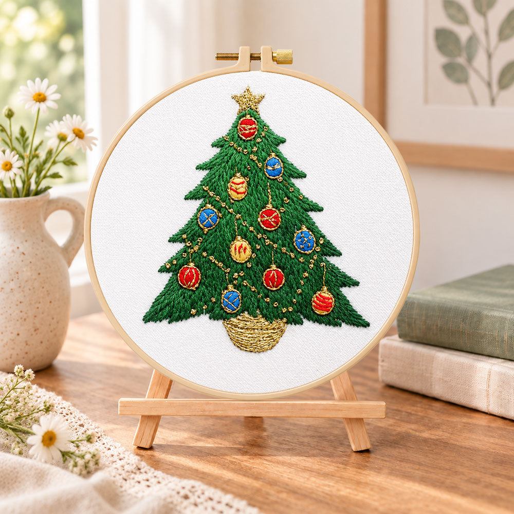 Colorful christmas tree embroidery kit finished hoop displayed on a wooden stand as cozy tabletop decor