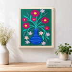 Finished colorful flowers in striped blue vase artwork displayed on a wall