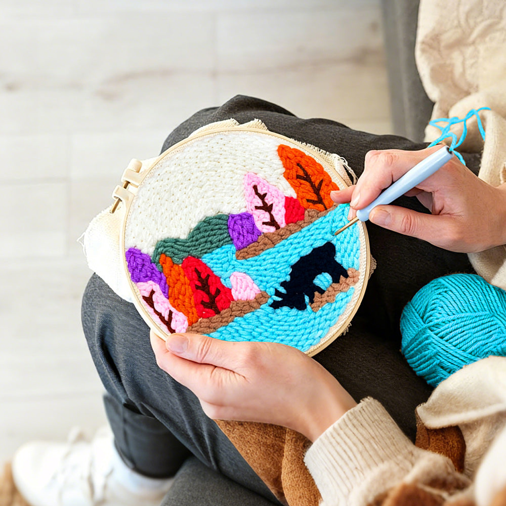 Creating handmade colorful forest above a lake punch needle artwork